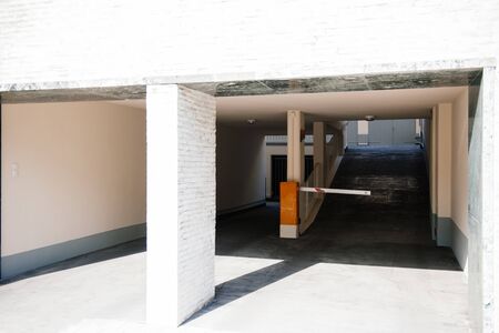 Main entrance to new garage gate with boom barrier entrance to office house residential buildingのeditorial素材