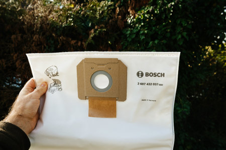 Strasbourg, France - Feb 9, 2020: Man hand holding Bosch professional vacuum cleaner bag for the Gas...
