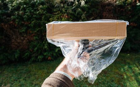 Man hand holding vacuum cleaner brush floor nozzle wrapped in plastic packageの写真素材