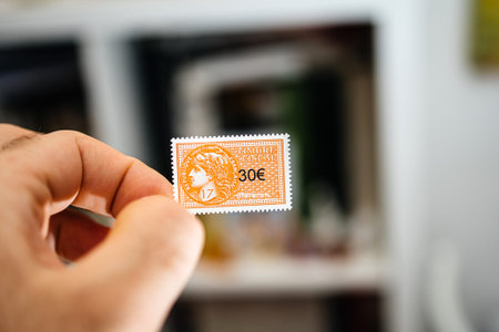 Paris, France - Mar 17, 2019: Man hand holding 30 euro fiscal revenue stamp timbre fiscale used for...