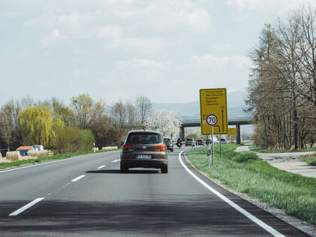 Germany - Mar 31, 2019: Driver POV at brown Volkswagen Tiguan SUV driving fast on rural highway with German black forest mountains in backgroundのeditorial素材