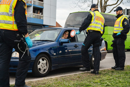 Kehl, Germany - Mar 16, 2020: An officer of the Federal Police checks driver at the border crossing...
