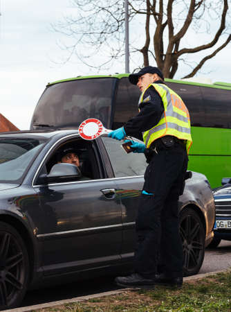 Kehl, Germany - Mar 16, 2020: An officer of the Federal Police checks passport and travel permit at the border crossing in Kehl from France Strasbourg during crisis measures against coronavirus.のeditorial素材