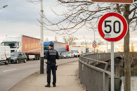 Kehl, Germany - Mar 16, 2020: Surveilling traffic German Polizei Police officer inspecting the border crossing in Kehl from France Strasbourg during crisis measures novel coronavirusのeditorial素材