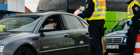 Kehl, Germany - Mar 16, 2020: Wide image of Federal Police officer checking permit ID at the border...