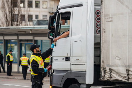 Kehl, Germany - Mar 16, 2020: An officer of the Federal Police checks truck driver permit at the border crossing in Kehl from France Strasbourg during crisis measures against novel coronavirusのeditorial素材