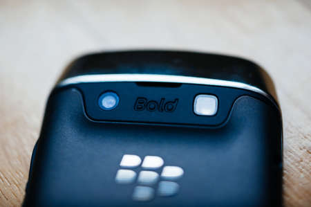 London, United Kingdom - Apr 21, 2013: Logotype on the vintage mobile smartphone communication Blackberry Bold telephone with qwerty keyboard focus on the rear cameraのeditorial素材