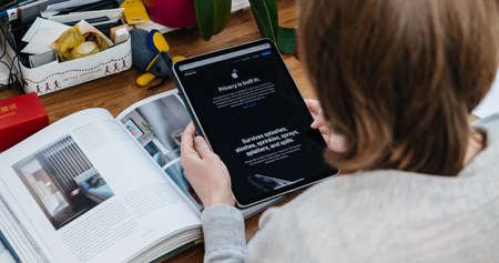 Paris, France - Apr 16, 2020: Privacy is built message on Apple Computers website as woman reads internet website on iPad Pro tablet in room environment showcasing new iPhone SEのeditorial素材