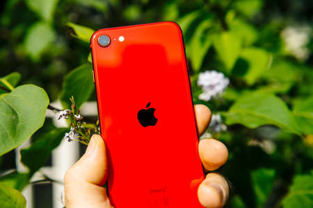 Paris, France - Apr 24, 2020: POV male hand holding new budget iPhone SE by Apple Computers touch ID, Single-lens rear camera and iPhone 8 design with internals from 11 Pro versionのeditorial素材
