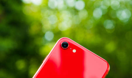 Paris, France - Apr 24 2020: Close-up of the new Single-lens rear camera on budget iPhone SE by Apple Computers touch ID, Single-lens rear camera and iPhone 8 design green bokeh backgroundのeditorial素材