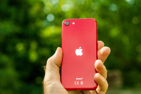 Paris, France - Apr 24, 2020: Man hand showing rear Logotype on new budget iPhone SE by Apple Computers touch ID, Single-lens rear camera and iPhone 8 design with internals from 11 Pro versionのeditorial素材