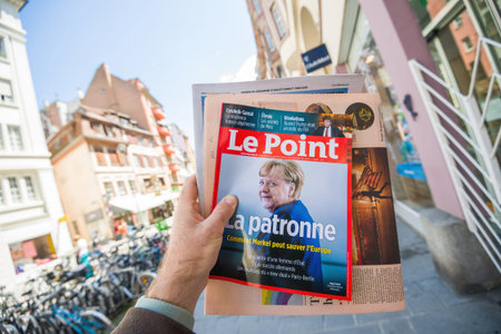 Paris, France - May 30, 2020: Man hand holding Le Point Magazine newspaper featuring Angela Merkel...