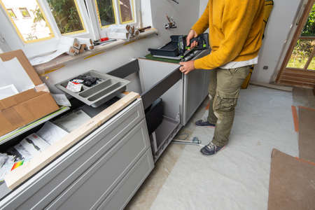 Paris, France - Jun 8, 2020: Male carpenter worker holding in hand Cordless drill T 18 plus 3 C 3,1-Plus manufactured by Festool Germany - kitchen reconstruction renovation an repairingのeditorial素材