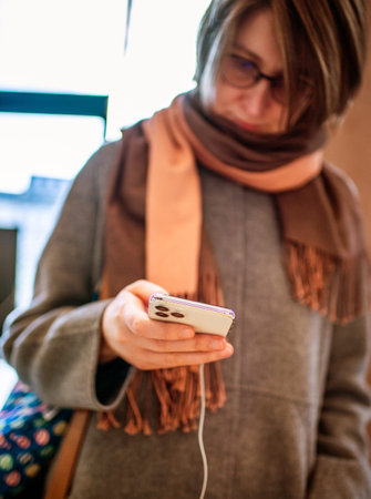 Paris, France - Nov 2019: Young beautiful French woman holding stainless steel new iPhone Pro 11 12 Max in hands by Apple Computers checking the price and its function - life before covid-19のeditorial素材