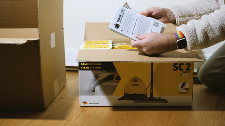 Paris, France - Circa 2019: Real scene of man unboxing in new house cardboard box from Amazon...