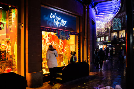 Strasbourg, France - Dec 4, 2020: People looking at the beautifully decorated showcase of Galleries lafayette department store during partial lockdown due to COVID-19のeditorial素材
