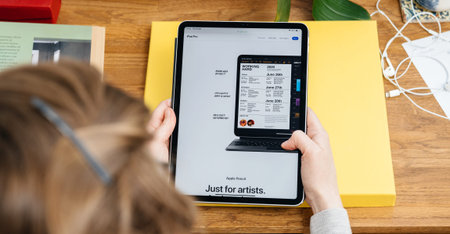 Paris, France - Apr 16, 2020: Woman looking on Apple Computers internet website on iPad Pro tablet...