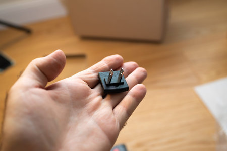 Male hand holding new type A outlet is the typical flat, two-pronged, ungrounded outlet used in...