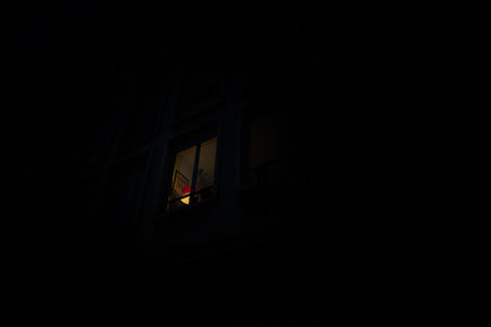 View from the street of a lonely lighten window with one light at dusk