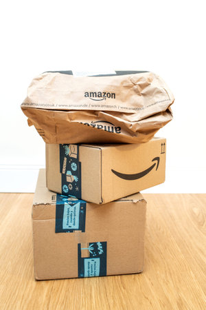 Paris, France - Dec 12, 2020: Stack of two rectangular cardboard packages and one paper bag with Amazon prime logotype with gifts inside during Christmas holiday seasonのeditorial素材