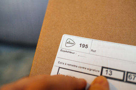 Paris, France - Dec 8 2020: Close-up macro view of male hand pointing to the Post NL Postal parcel from Netherlandsのeditorial素材