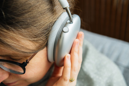 Paris, France - Jan 7, 2020: musicophile woman listens to new Apple Computers AirPods Max over-ear...