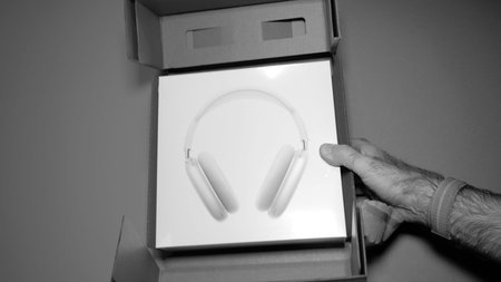Paris, France - Jan 7, 2020: POV male hand holding package of the best Apple Computers AirPods Max...