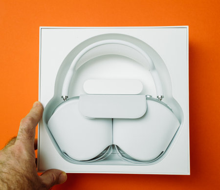 Paris, France - Jan 7, 2020: POV male hand on best Apple Computers AirPods Max over-ear headphones admiring best productのeditorial素材