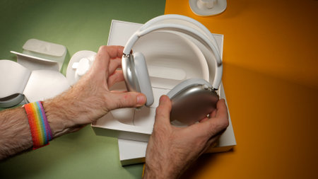 Paris, France - Jan 7, 2020: POV male hand holding best Apple Computers AirPods Max over-ear headphones with Adaptive EQ, Active Noise Cancellation, Transparency mode h1 chips and Siriのeditorial素材