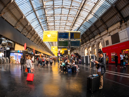 Paris, France - May 20, 2018: Large crowd of people inside Gare de Est in Paris commuting with luggage reading newspaper waiting for the trains TGVのeditorial素材