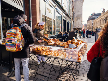 Strasbourg, France - Feb 23, 2018: Customers being served at the outdoor market stall bagels french croissants and other bakeries from Paul pastries store boulangeriesのeditorial素材