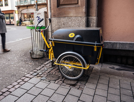 Strasbourg, France - Feb 23, 2019: French postal carriage with logotype of the national la Poste operator parked on a corner of the street pedestrian on the streetのeditorial素材