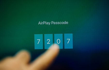 Paris, France - Nov 18, 2018: Pov male hand touching on the tv screen the AirPlay Passcode in order to stream from smartphone phone to Apple tv setのeditorial素材