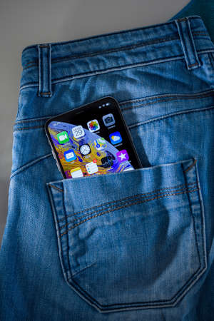 Paris, France - Sep 29, 2018: Rear view of denim jeans rear pocket with new Apple Computers Smartphone featuring OLED retina screen and multiple apps on the display screenのeditorial素材