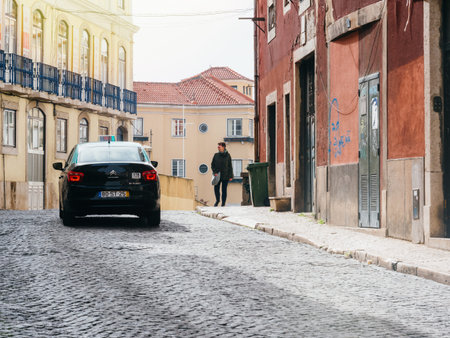 Lisbon, Portugal - Feb 9, 2018: Smiling Portuguese woman walking on the street with cobblestone...