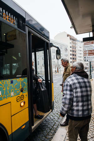 Lisbon, Portugal - Feb 9, 2018: Senior men waiting to enter yellow public transportation bus at central station - Atomic Urbis model busのeditorial素材