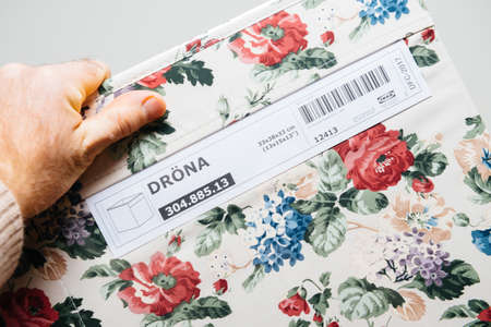 Paris, France - FEb 8, 2021: POV male hand holding new colorful floral Drona package cardboard box for objects deposit manufactured by the Swedish IKEAのeditorial素材