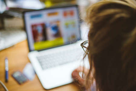 CLose-up focus on the eyewar of woman working on the laptop from home teleworkingの写真素材