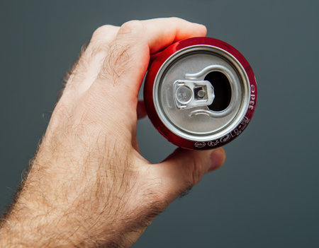Paris, France - May 3, 2020: POV male hand holding top of aluminum can of Dr Pepper manufactured by Dr Pepper Snapple Group soft sweet drinks - isolated against gray background - recycling conceptのeditorial素材