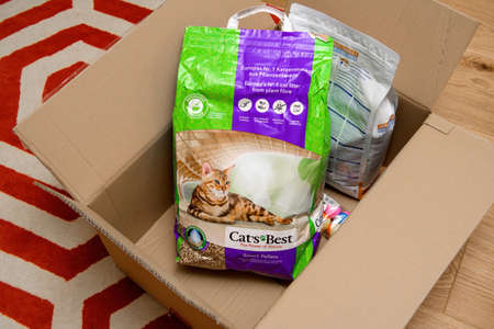 Strasbourg, France - Jan 16, 2021: Overhead view of Living room carpet with cardboard box delivery containing Cats Best litter wood bio organic and Royal Canin Senior Consult stage cats foodのeditorial素材