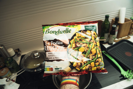Paris, France - Feb 13, 2021: POV male hand holding package with delicious Bonduelle La Poele Rustique - dried traditional french rustic vegetables - ready to eat just put on hot hobのeditorial素材