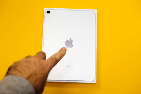Paris, France - Feb 4, 2021: POV male hand holding looking at the new Apple Computers iPad Pro with famous brand logotypeのeditorial素材
