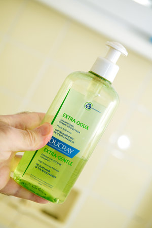 Paris, France - Apr 8, 2020: POV personal perspective male hand holding bottle with Ducray extra-soft french shampooのeditorial素材