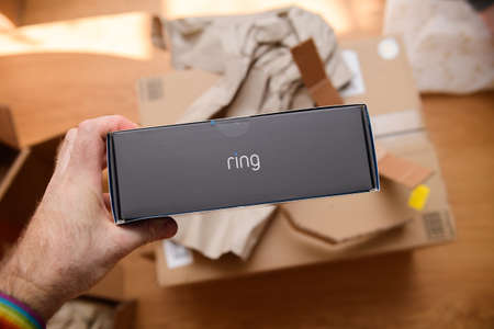 Paris, France - Feb 21, 2021: POV male hand holding before unboxing recent parcel with package of new latest Amazon Ring product with logotype on the sideのeditorial素材