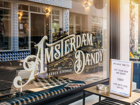 Haarlem, Netherlands - Aug 21, 2018: View from the street of vintage inscription Amsterdam Dandy by Barber birdman on the main street in Dutch cityのeditorial素材