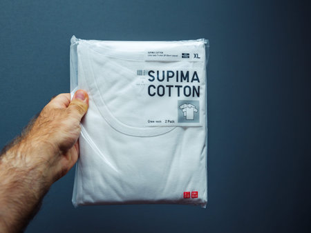PAris, France - Sep 21, 2018: POV male hand holding package of new Supima Cotton Cred Neck t-shirt...