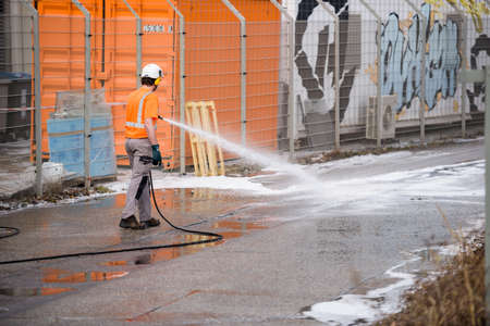 Strasbourg, France - Mar 10, 2021: Man cleans street after burnt remains of the large data center - Millions of websites offline after fire at French cloud services firm OVH Cloud in Strasbourg Franceのeditorial素材