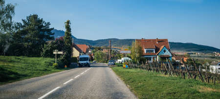 Rorschwihr, France - Apr 19, 2019: Large view entrance from the main highway to the Rorschwihr village in Alsace with mountains and church in backgroundのeditorial素材