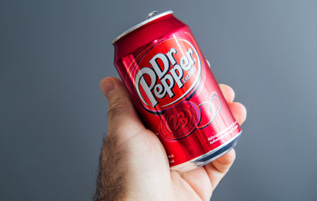 Paris, France - May 3, 2020: Hero object holding pov male hand holding aluminum can of Dr Pepper manufactured by Dr Pepper Snapple Group soft sweet drinks - isolated against gray backgroundのeditorial素材