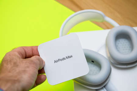Paris, France - Jan 7, 2021: Close-up of ear cup vent on AirPods Max wireless Bluetooth over-ear headphones created by Apple Computers with male hand holding the instruciton manual of the deviceのeditorial素材